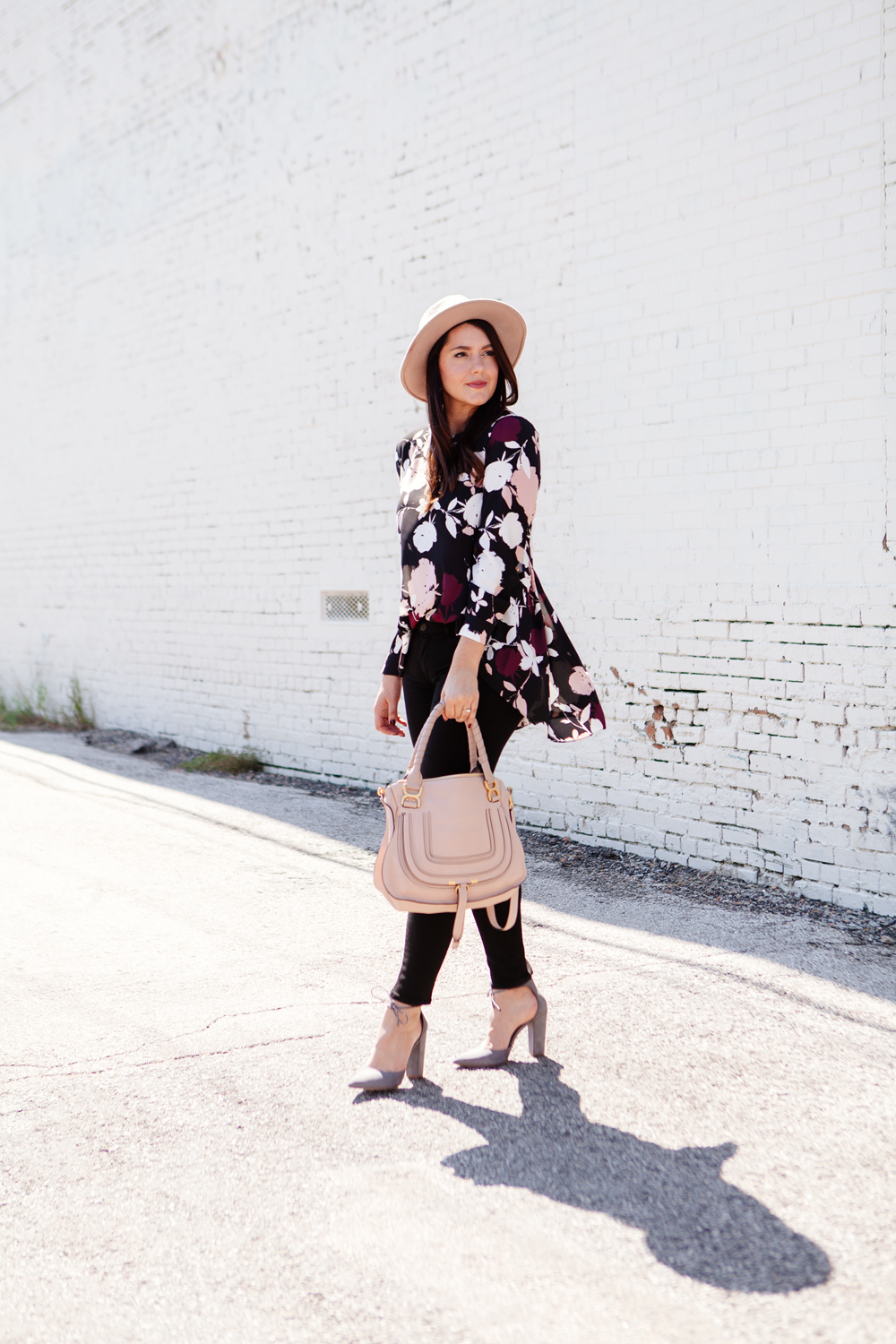 Floral blouse with black skinny jeans and blush hat and purse on Kendi Everyday